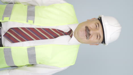 Vertical-video-of-The-old-engineer-wearing-a-hard-hat-and-smiling.